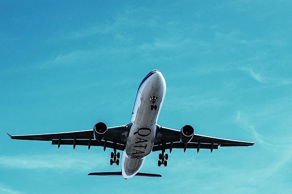 Flugzeug in der Luft vom Boden aus gesehen, vor blauem Himmel